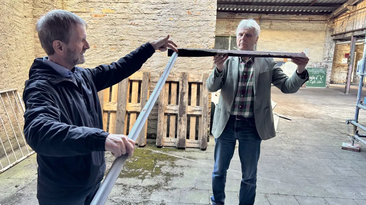 Holger Schmidt und Roland Ladusch (r.) zeigen, dass auch die Halterung vom filigranen Oberlicht der Verladerampe am Neufert-Bau in Weißwasser marode ist und ausgetauscht werden muss.