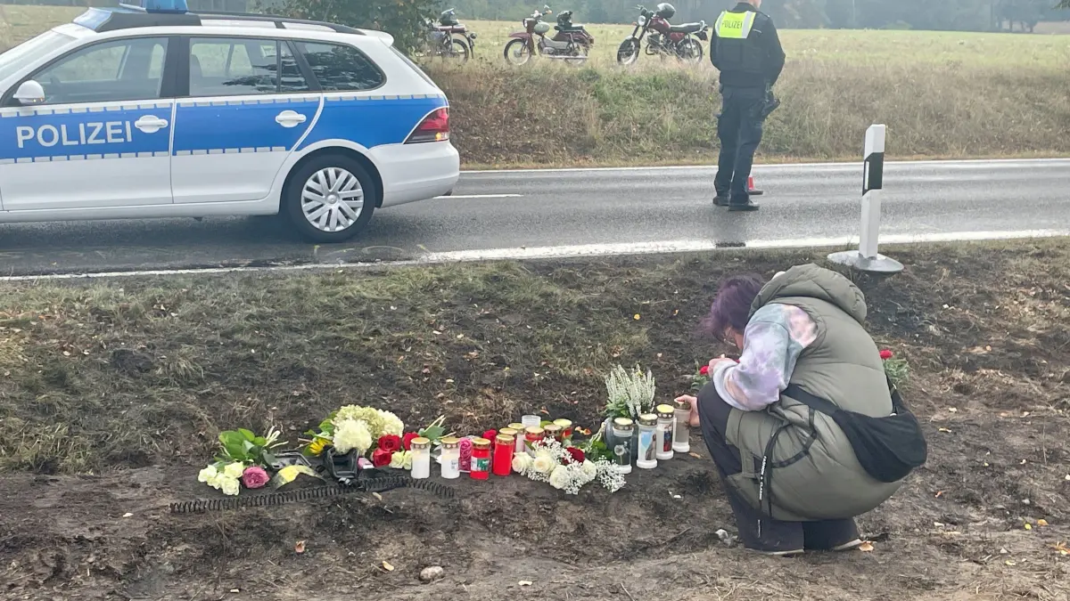 Eine Trauernde stellt eine Kerze an der Unfallstelle zwischen Bernau und Biesenthal auf. Am Tag nach dem Tod von vier jungen Menschen kommen viele mit Blumen und Kerzen hierher.