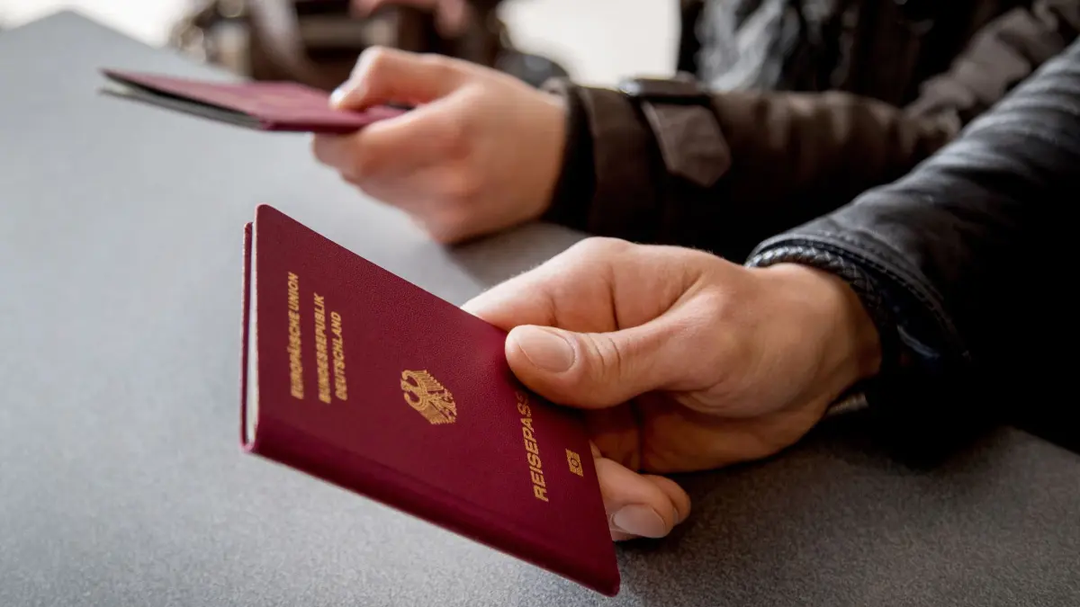 Mann hält einen Reisepass in der Hand: Reisegenehmigungen wie ETA und ESTA sollten ausschließlich über staatliche Internetseiten oder Apps beantragt werden. (zu dpa: «Vorsicht vor Abzocke mit Reisegenehmigungen»)
