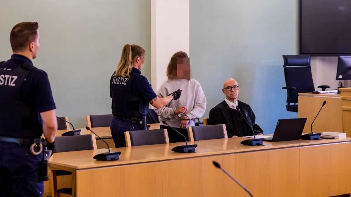 Prozess in Cottbus: Die als schwere Brandstifterin angeklagte Frau (22) wird aus der U-Haft in den Gerichtssaal geführt. Ihr Verteidiger, Rechtsanwalt Olaf Klemke (r.), hat jetzt ihr voll umfängliches Geständnis verlesen. Eine Frage aber bleibt weiter offen.