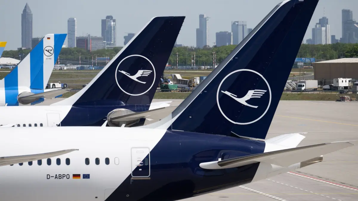 Lufthansa-Maschinen am Flughafen Frankfurt: ARCHIV - 28.04.2026, Hessen, Frankfurt/Main: Passagiermaschinen der Lufthansa und der Condor stehen am Flughafen Frankfurt, während im Hintergrund die Bankentürme von Frankfurt zu sehen sind. (zu dpa: «Kerosin-Mangel am Flughafen Frankfurt - Lufthansa reagiert») Foto: Boris Roessler/dpa +++ dpa-Bildfunk +++