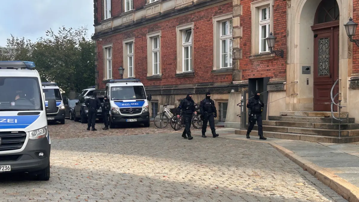 Für den Prozess gegen die organisierte Kriminalität hat das Landgericht Cottbus verschärfte Sicherheitsmaßnahmen angeordnet. Vermummte Spezialeinheiten sichern das Areal ab und schützen einen Zeugen.
