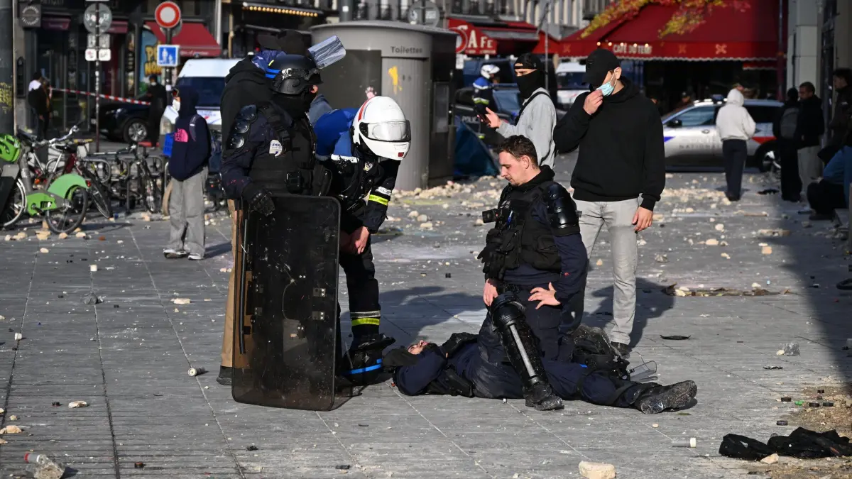 Protesttag in Frankreich: Ein Polizist liegt verletzt am Boden während einer Demonstration gegen steigende Lebenshaltungskosten, bei der sich die Teilnehmer den Forderungen der Studenten anschlossen haben. (zu dpa: «400 Festnahmen und 60 verletzte Polizisten in Frankreich»)