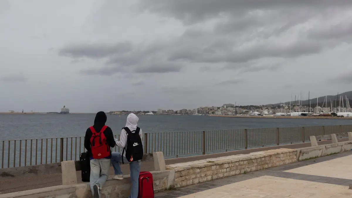 Wetter auf Mallorca: 18.10.2026, Spanien, Palma: Menschen am Meer auf der Strandpromenade von Palma. Der Sturm „Adam“ zieht gerade über die Insel hinweg, und für die Bevölkerung wurde eine rote Warnstufe ausgerufen. Foto: Clara Margais/dpa +++ dpa-Bildfunk +++