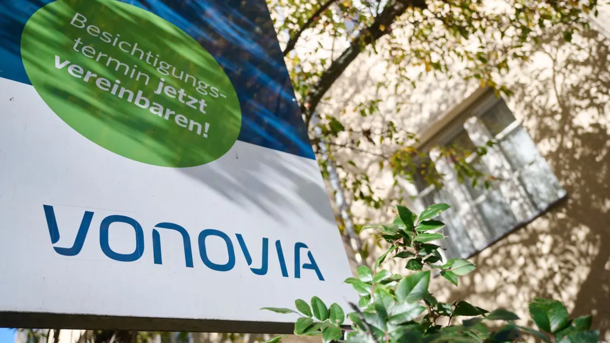 Vonovia: Das Logo des Wohnungsunternehmens Vonovia steht auf einem Schild vor einem Mehrfamilienhaus. (zu dpa: «Vonovia: Vergesellschaftung in geplanter Form nicht machbar»)
