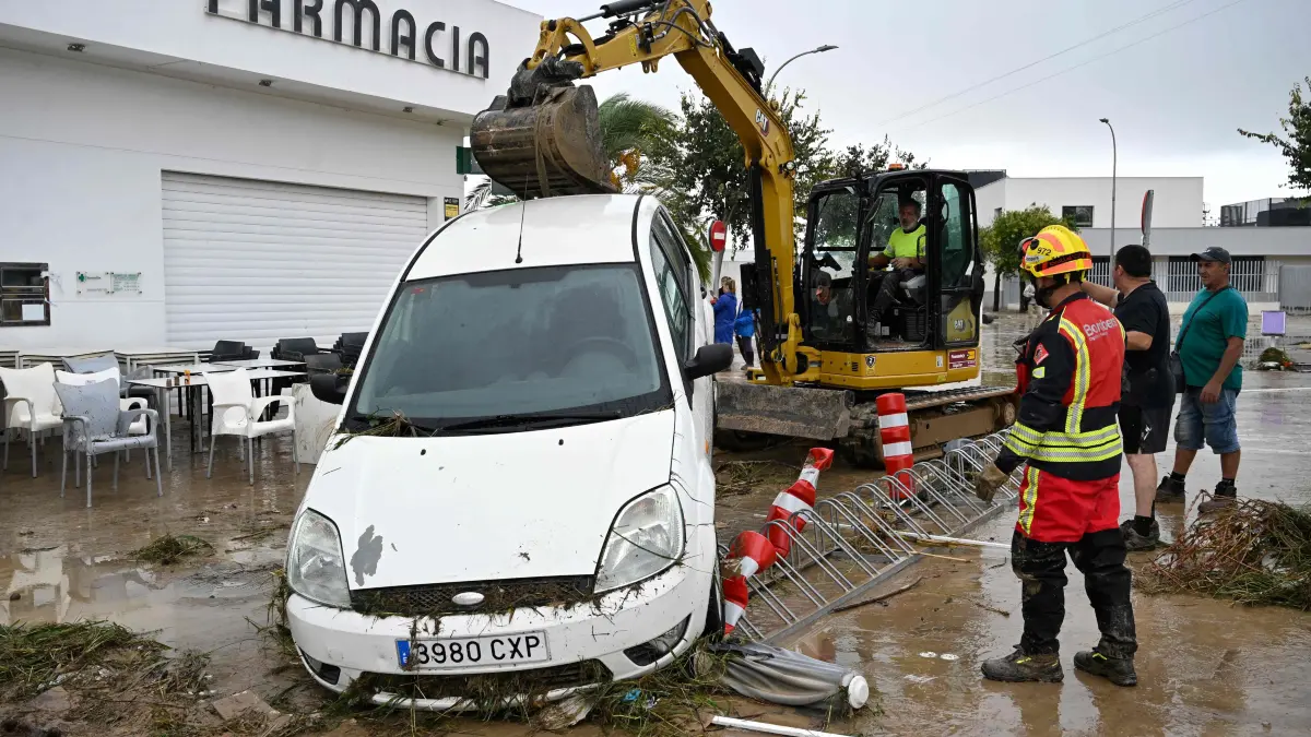 SPAIN-WEATHER-CLIMATE-FLOOD: An excavator removes a flood-damaged car following torrential downpours in Els Poblets, eastern Spain, on October 19, 2026. At least two people have died after heavy rain triggered flooding in eastern Spain, authorities said today, as rescuers worked to evacuate stranded residents and officials urged people in the Valencia region to stay indoors. (Photo by Jose JORDAN / AFP)