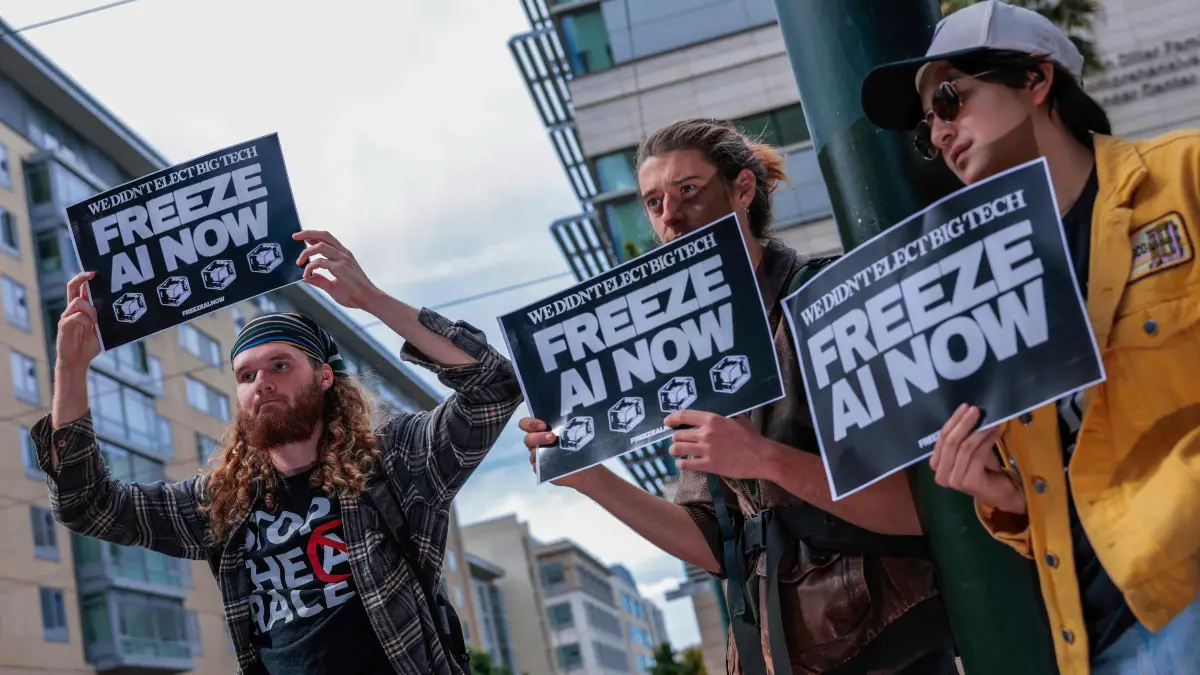 Walkout Held Nationwide To Protest AI Development: SAN FRANCISCO - OCTOBER 20: Protesters hold up "Freeze AI Now" signs outside of Open AI headquarters on October 20, 2026 in San Francisco, California. One of the protest groups, Irreplaceable, organized protests across the United States as part of a day of national walkouts, calling for a freeze on AI development. Heather Diehl/Getty Images/AFP (Photo by Heather Diehl / GETTY IMAGES NORTH AMERICA / Getty Images via AFP)