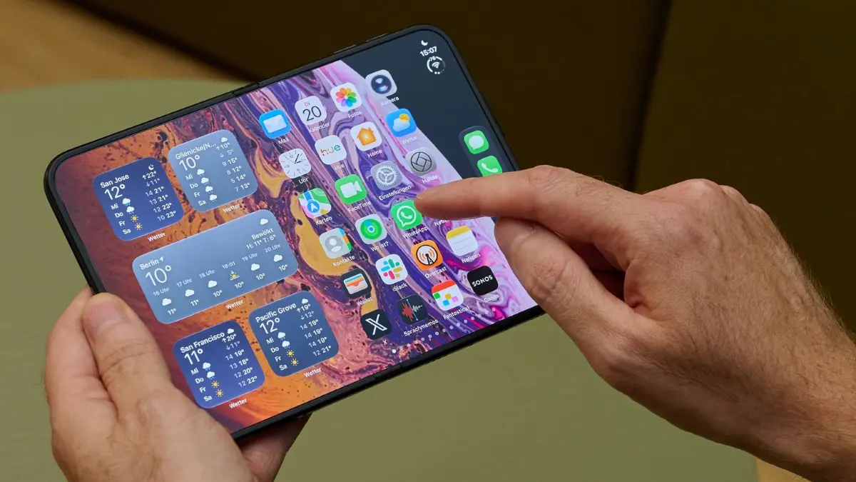 Ein Mann hält das iPhone Duo in den Händen : Das iPhone Duo bietet aufgeklappt ein Display im Tablet-Format. (zu dpa: «iPhone Duo im Test: Das Apple-Tablet für die Hosentasche»)