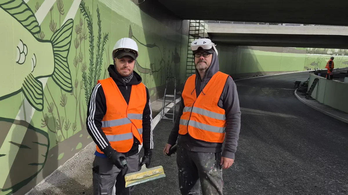 Die Straßenunterführung in Lübbenau ist auch Arbeitsplatz für die Fassadengestalter Mariano Schuhmacher (li.) und Andreas Dorn. Mit ihren Kollegen bringen sie eine Spreewalduferlandschaft auf die Betonwände.