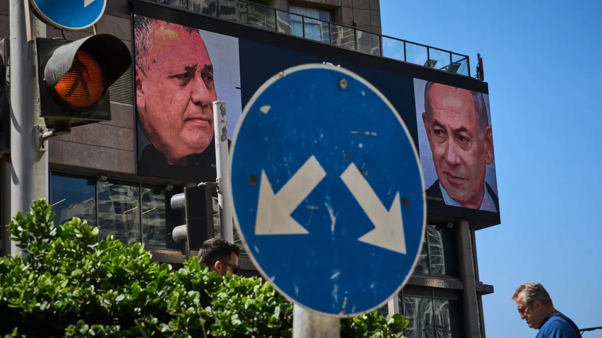 Vor den Wahlen in Israel: ARCHIV - 23.09.2026, Israel, Ramat Gan: Ein Mann geht an einer Werbung vorbei, auf der der israelische Ministerpräsident Benjamin Netanjahu (r) und sein Hauptkonkurrent, der Oppositionskandidat Gadi Eisenkot, im Vorfeld der Parlamentswahlen in Israel zu sehen sind. Am 27. Oktober soll ein neues israelisches Parlament gewählt werden. (zu dpa: «Was bedeutet die Wahl in Israel für Krieg und Frieden?») Foto: Oded Balilty/AP/dpa +++ dpa-Bildfunk +++
