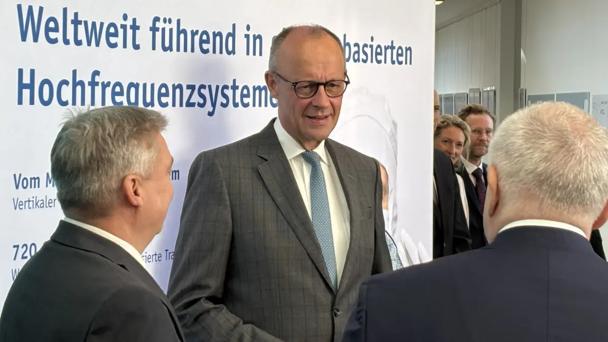 Prof. Gerhard Kahmen von der BTU Cottbus-Senftenberg (l.) und Prof. Christoph M. Schmidt, Präsident der Leibniz-Gemeinschaft, begrüßen Bundeskanzler Friedrich Merz im Leibniz-Institut für innovative Mikroelektronik (ihp) in Frankfurt (Oder)