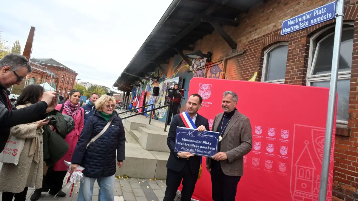 Montreuiler Platz Einweihung: Montreuils Bürgermeister Patrice Bessac (l.) und der Cottbuser Oberbürgermeister Tobias Schick mit einem Schild, das an den Montreuiler Platz in Cottbus erinnert.
Montreuiler Platz feierlich eingeweiht
Cottbus am Freitag und Samstag seine Städtepartnerschaften mit Montreuil und Grosseto gefeiert. Dafür kamen Gäste aus Frankreich und Italien in die Lausitz. Auf dem Programm standen eine Baumpflanzung im Branitzer Park, ein Eintrag ins Goldene Buch der Stadt, ein Streetsoccer-Cup und die French Night im Gladhouse. Als besonderer Höhepunkt ist am Samstag der Montreuiler Platz auf dem nördlichen Bahnhofsvorplatz eingeweiht worden. Im Mittelpunkt standen die langjährige Partnerschaft zwischen Cottbus und der französischen Stadt Montreuil sowie der italienischen Stadt Grossetto.