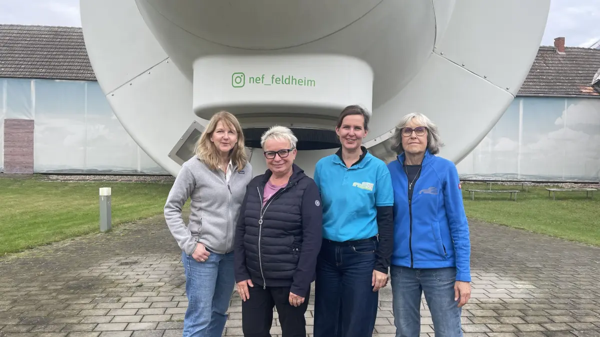 Vorsitzende des Neuen Energien Forums Feldheim (nef) Doreen Raschemann, Ortsvorsteherin Petra Richter, Guide Kathleen Thompson und Organisatorin Susanne Sombert vor der Gondel einer der ersten Windkraftanlagen am Neue Energien Forum Feldheim. (von links)
