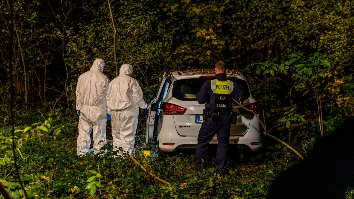 Spurensicherung der Polizei: In Neuendorf wurde in einem Waldstück in der Nähe des Teupitzer Sees am Mittwoch ein toter Mann gefunden. Der Pkw hat ein Kennzeichen von Dahme-Spreeald.