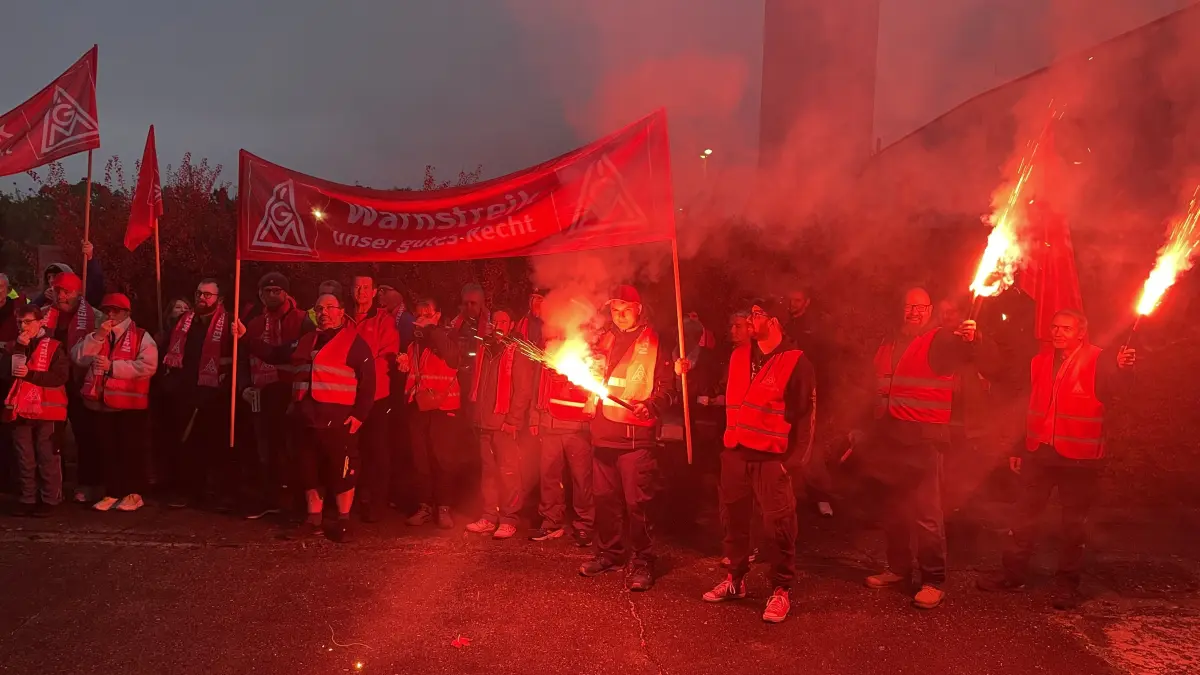 Kämpferische Stimmung und Bengalofeuer beim Warnstreik bei HQM in Massen. Die Belegschaft will mehr Geld, so geht die Geschäftsführung mit den Forderungen mit.