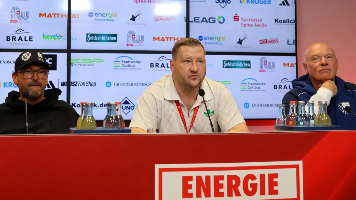 Fussball 2. Bundesliga 2026/2027 FC Energie Cottbus - VfL Bochum: Pressekonferenz nach dem Spiel, Trainer Claus-Dieter Wollitz (Energie Cottbus), FCE-Pressesprecher Stefan Scharfenberg-Hecht, Trainer Uwe Rösler (Bochum, r.)
