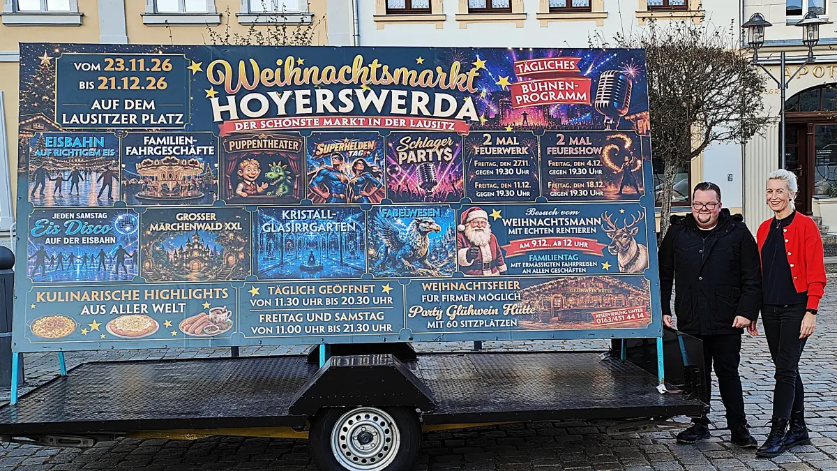 Veranstalter Joe Probst, Veranstalter und Anja Hillmann von der Lausitzhalle Hoyerswerda präsentieren den Werbeaufsteller für den Weihnachtsmarkt in Hoyerswerda. Er wird gegenüber dem Lausitzbad aufgestellt.